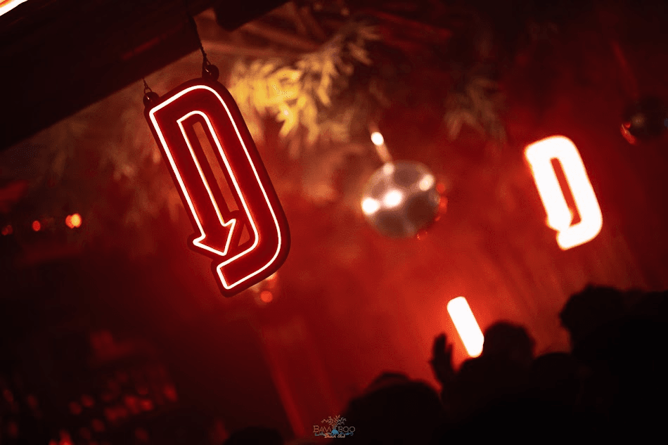 DESCEND event — the red neon 'D' logo glowing over a dark, atmospheric dancefloor